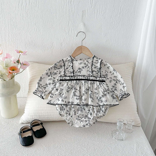 Floral baby romper bodysuit with ruffled sleeves and black waist trim, button snaps