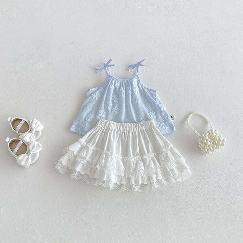 Light blue sleeveless floral dress with white tiered ruffle skirt and bow straps