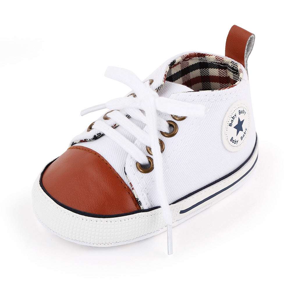 Baby canvas shoes in white with brown-orange side panel, lace-up front, star patch