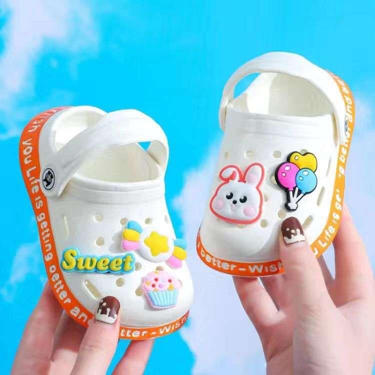White kids' slip-on clogs with cartoon patches and ventilation holes