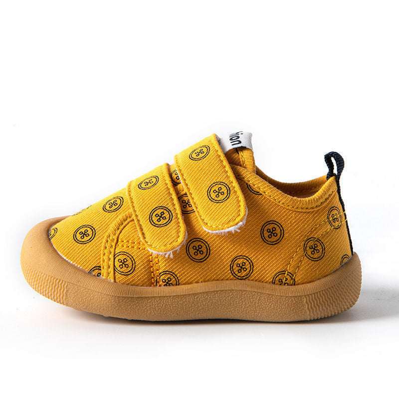 Warm yellow cloth toddler shoes with circular print, hook-and-loop straps, tan sole