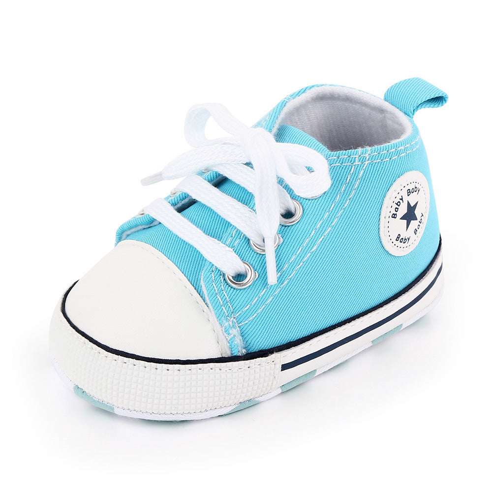 Baby canvas shoes in light blue with white toe, lace-up front, and star patch on side