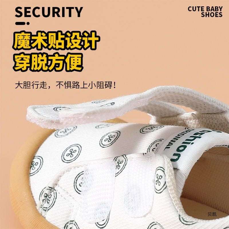 White cloth toddler shoe with circular pattern and hook-and-loop strap, tan sole edge