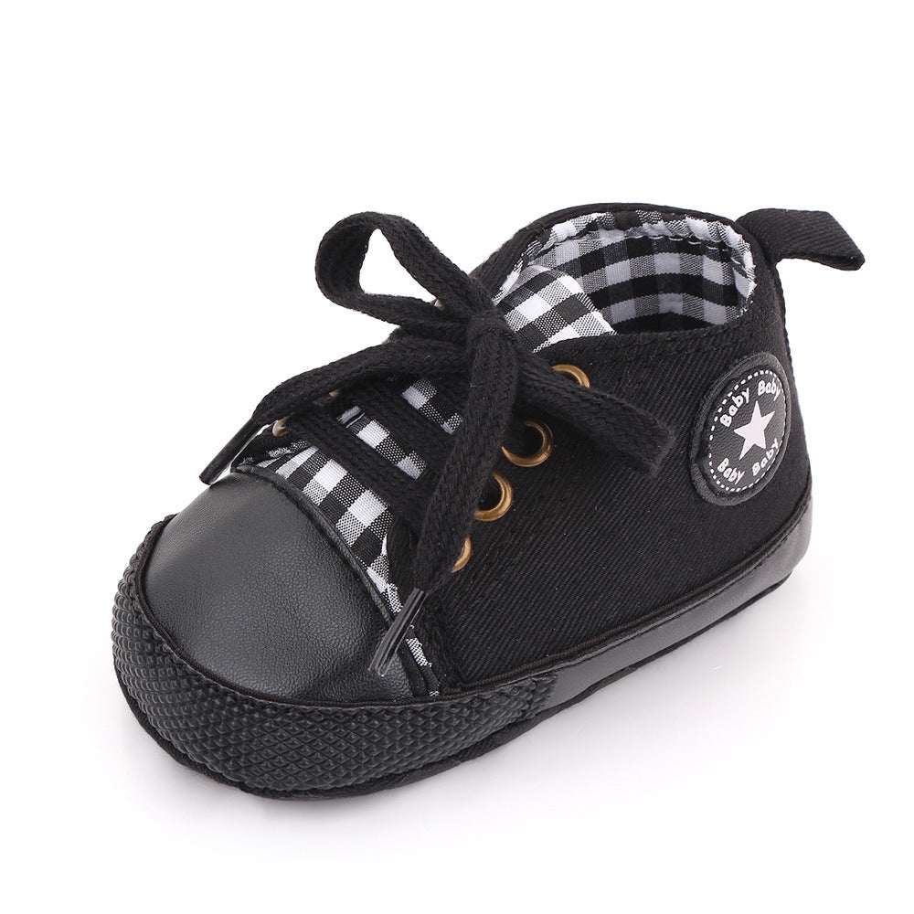 Baby canvas shoes in black with plaid lining and lace-up front, star patch on side