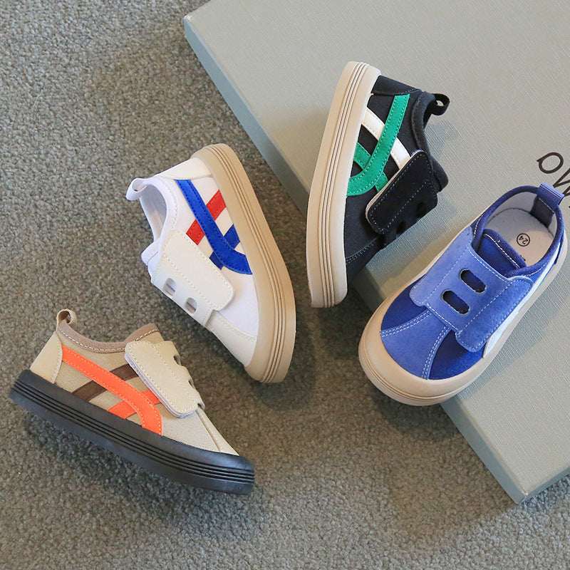 Kids canvas sneakers in mixed colors on floor, Velcro pairs in blue, beige, and black
