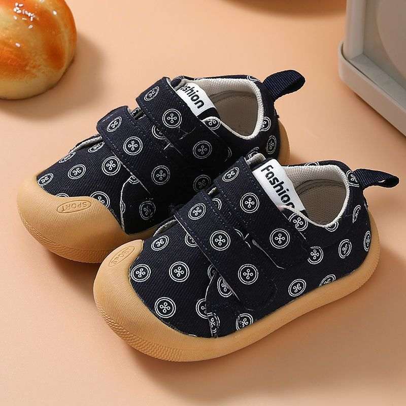 Navy cloth toddler shoes with circular print, teal pull tab, and tan non-slip sole