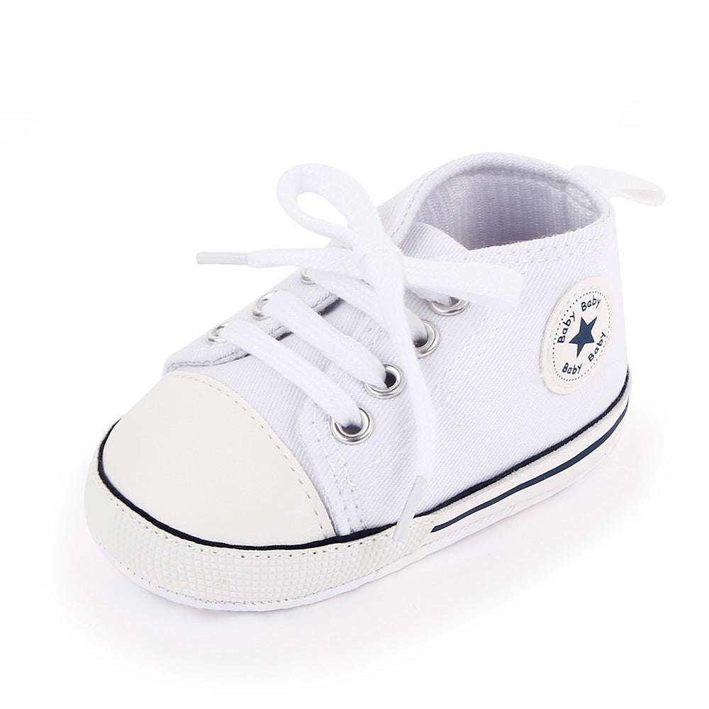 White baby canvas sneakers with white laces and star patch on side