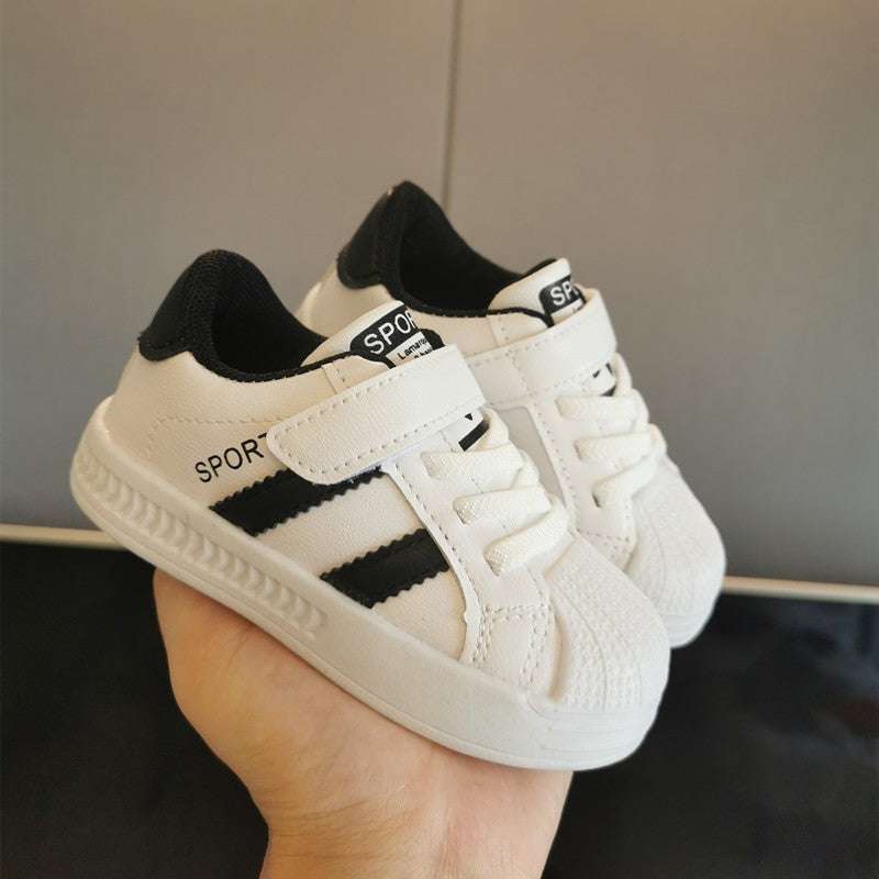Baby velcro sneakers, white upper with black panels and gum sole, pair shown at angle.