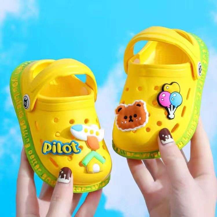 Yellow kids' slip-on clogs with cartoon patches and ventilation holes
