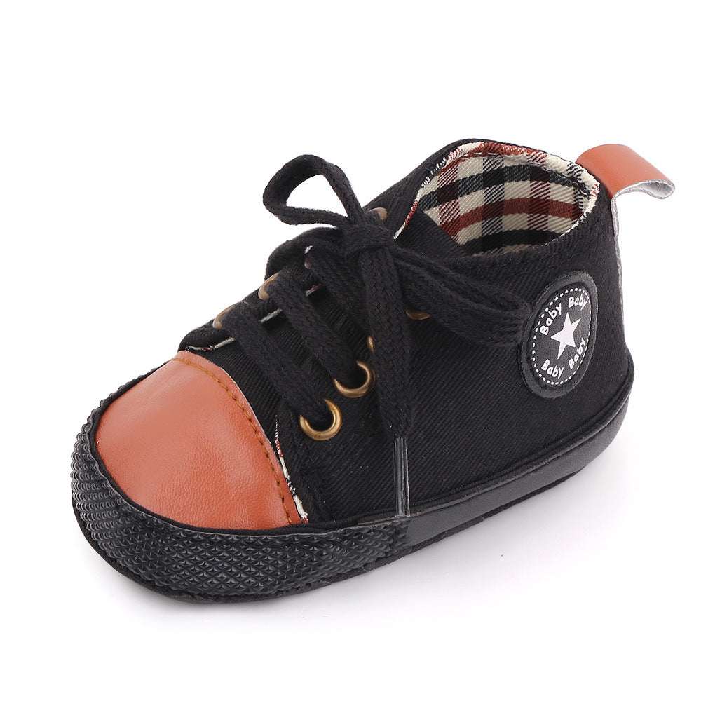 Baby canvas shoes in black with tan-orange side panel, lace-up front, star patch