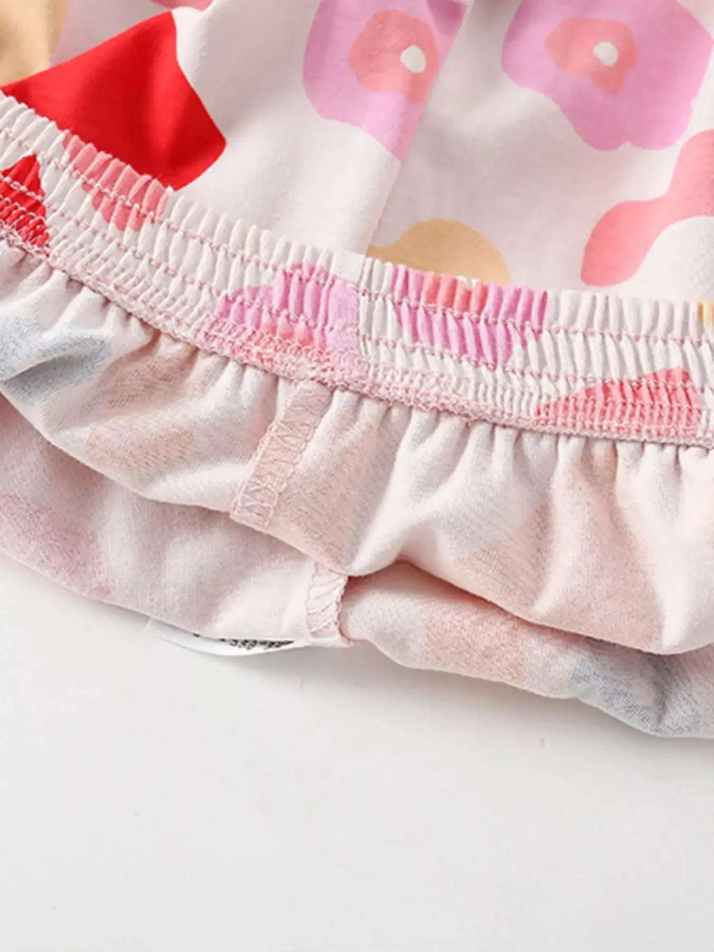 Children's printed top hem with elastic ruffle trim and pink-red block motifs