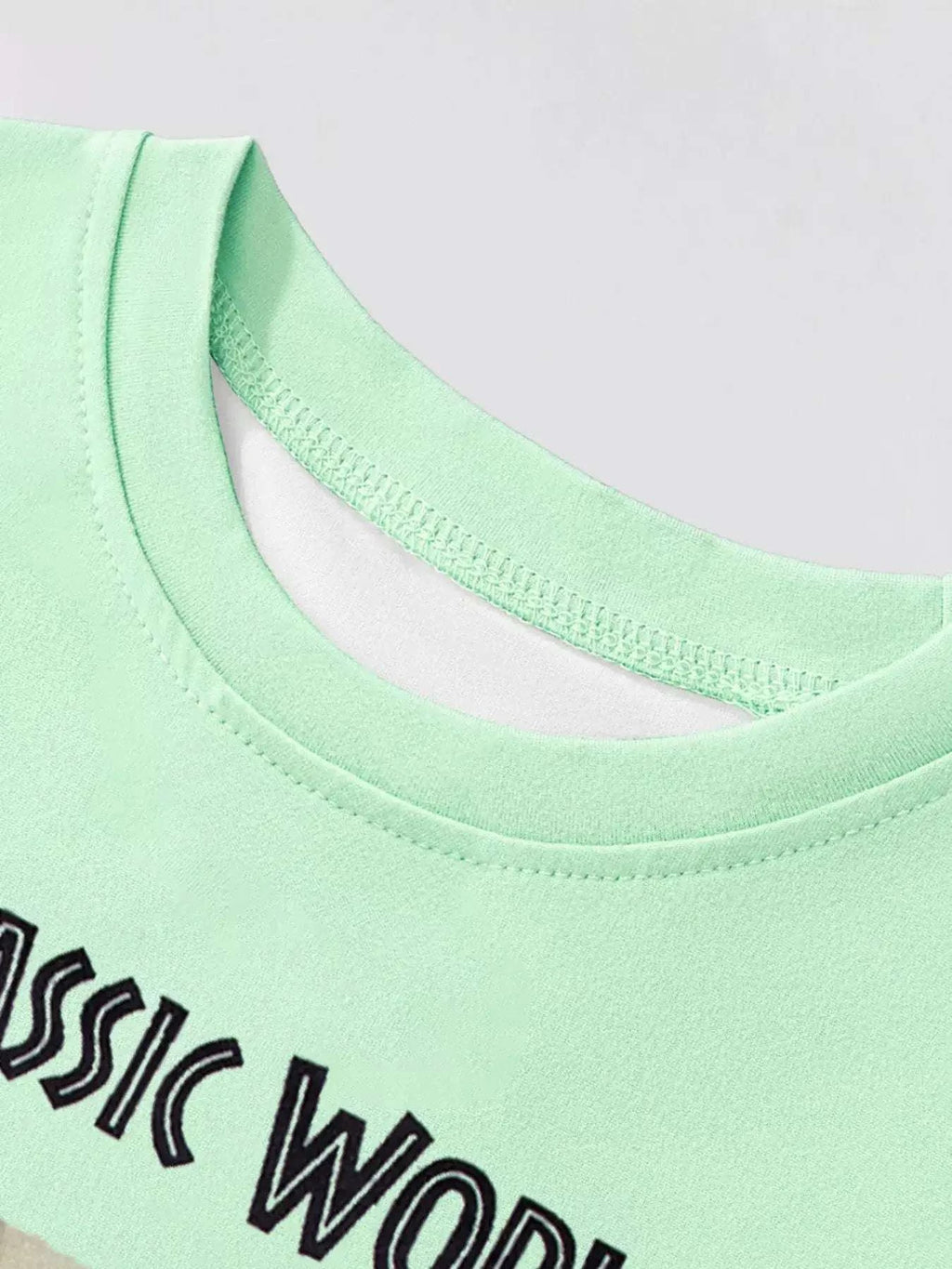 Neon green kids graphic T-shirt with crew neck; partial Jurassic World print