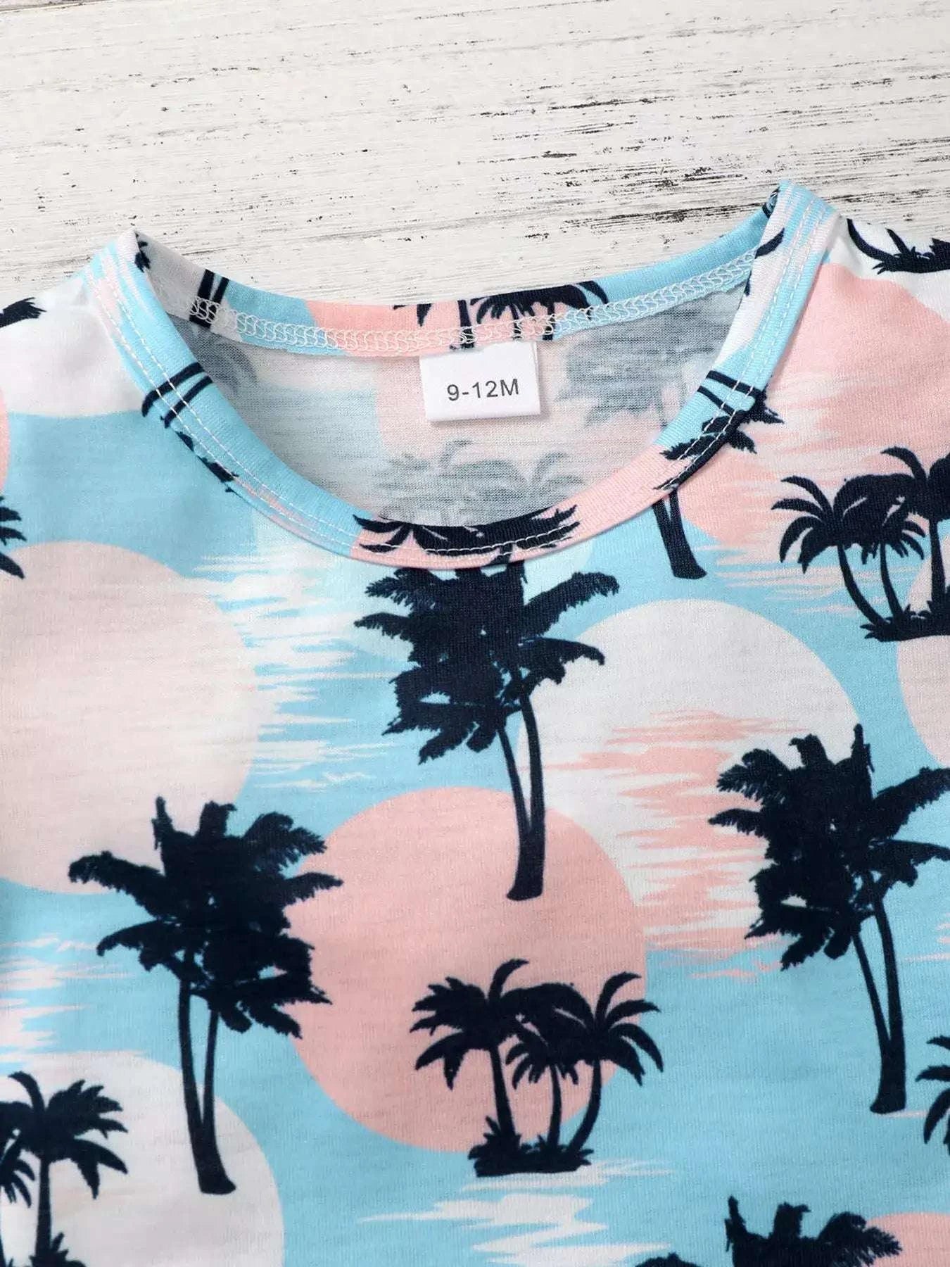 Kids palm print tee, crew neck with light blue background and black palm silhouettes