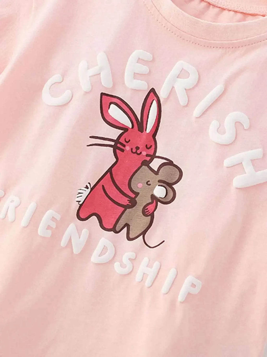 Blush pink kids graphic tee with bunny hug design and curved friendship lettering