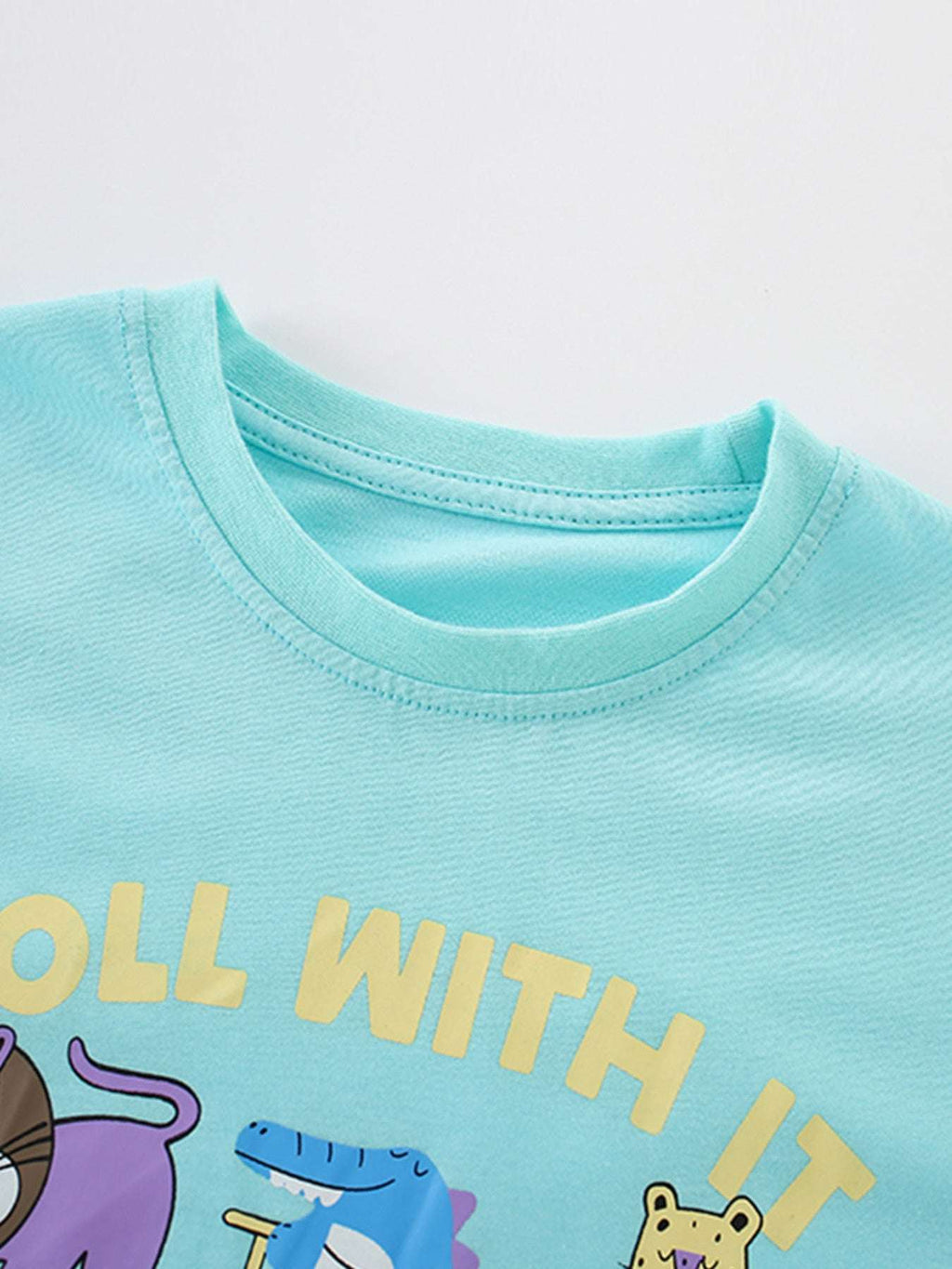 Children's aqua tee close-up: crew neck and partial animal graphic text