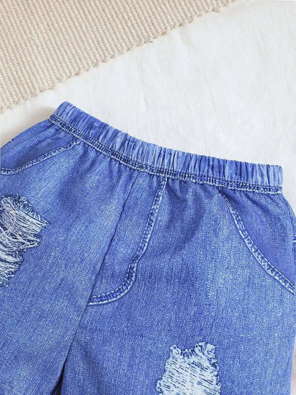 Blue denim ripped shorts with frayed patches and elastic waistband