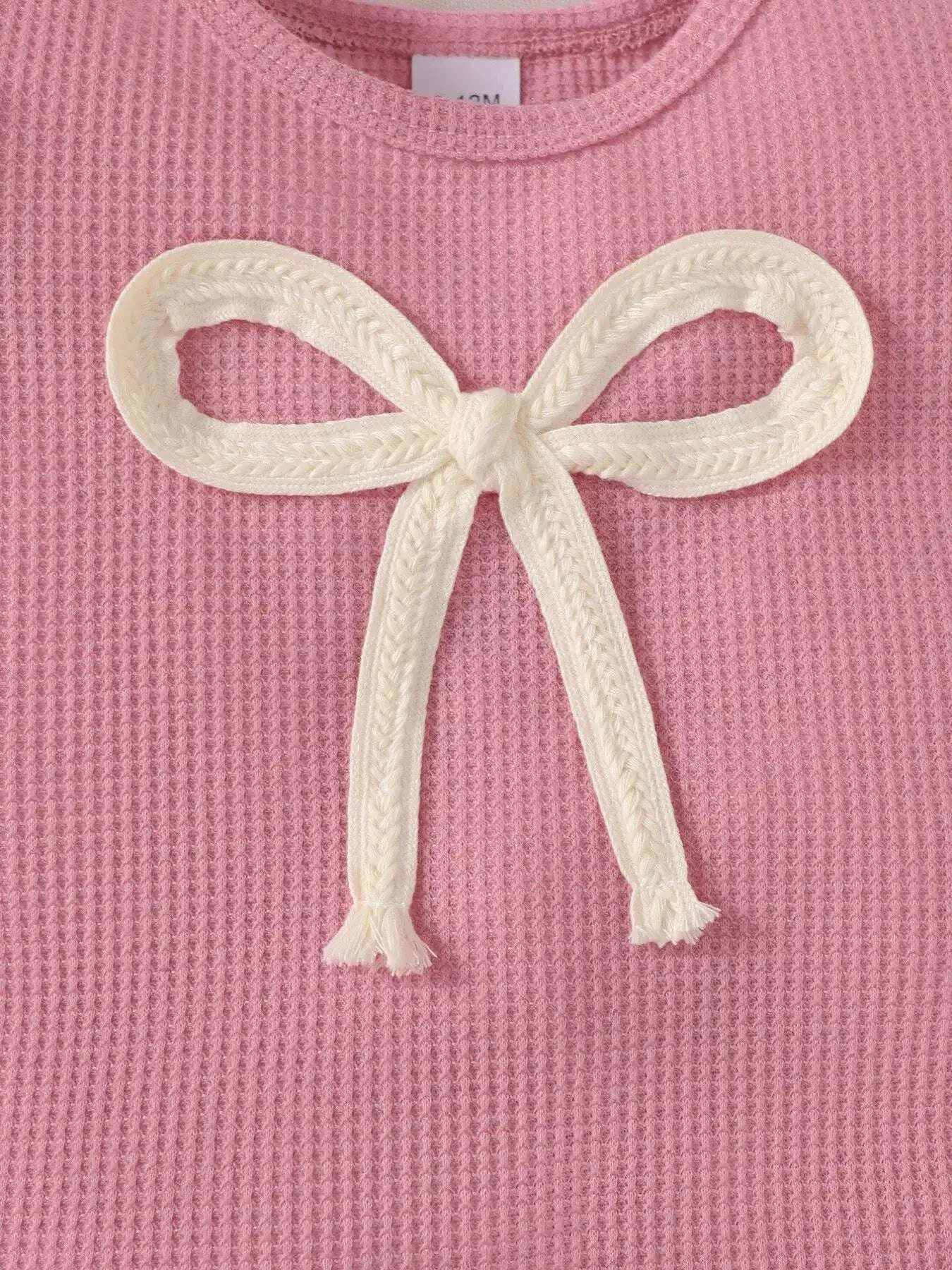 Pink knit top front with large white bowknot applique