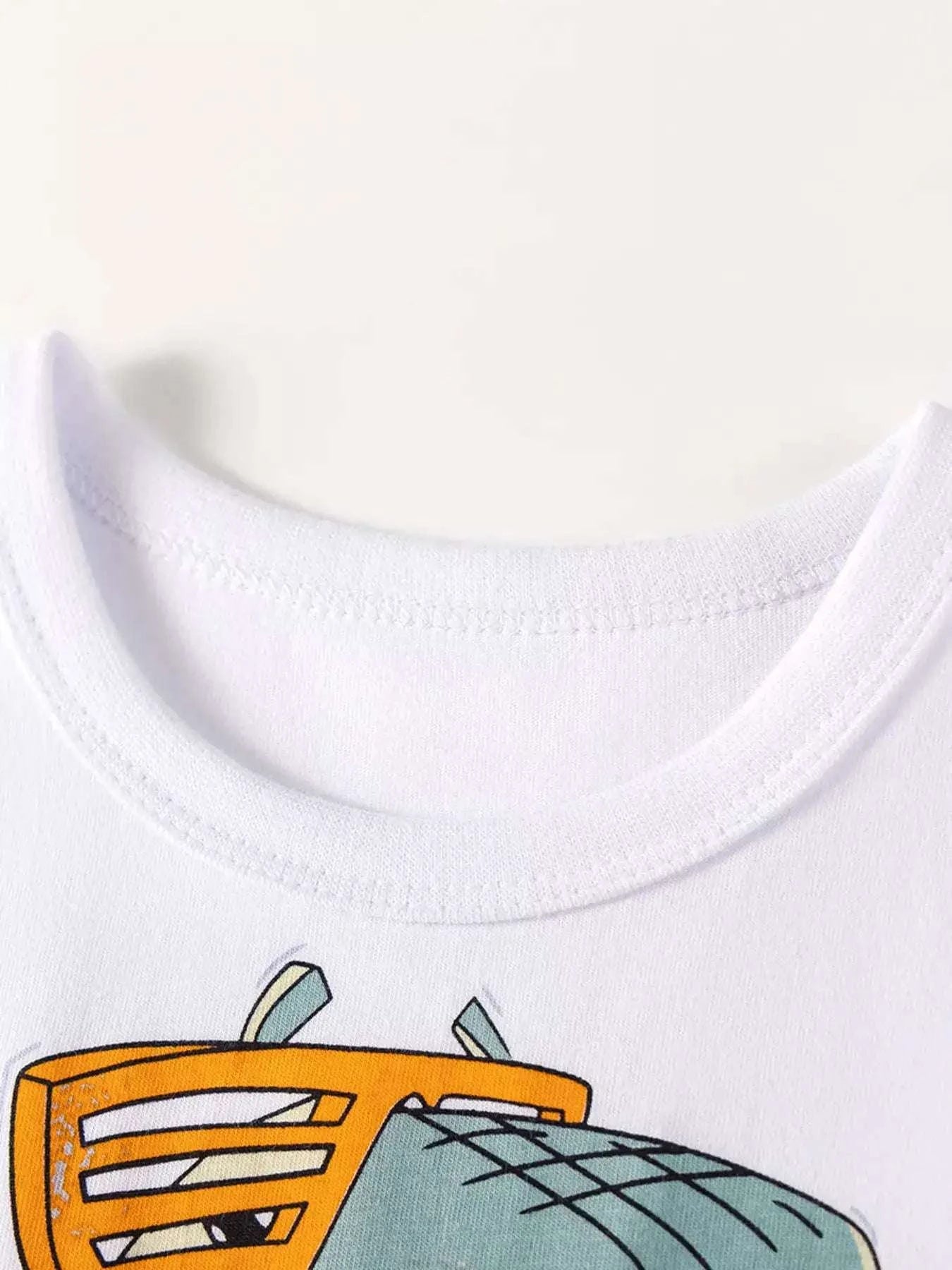 White kids dinosaur graphic tee neckline, close-up view with partial print