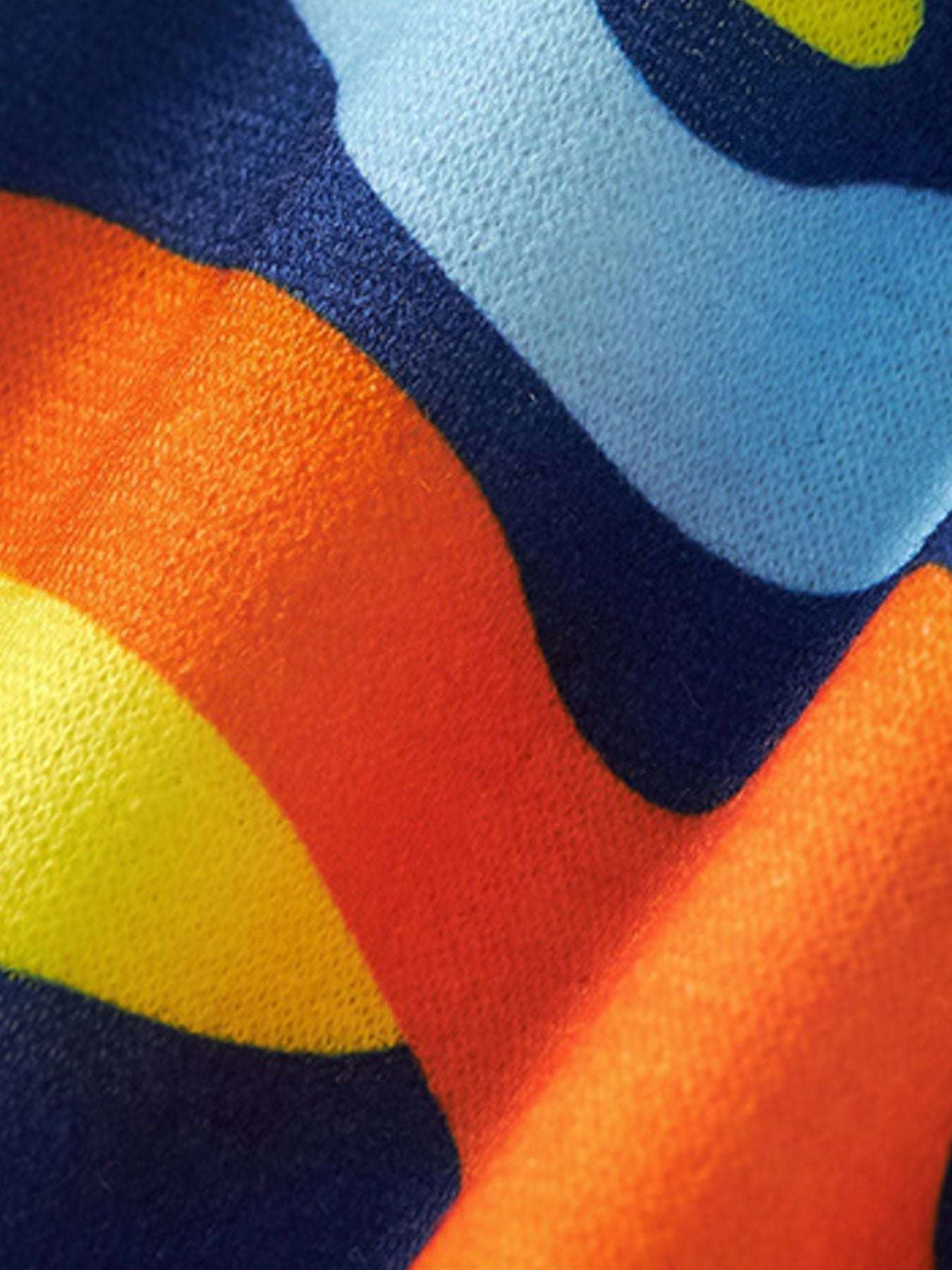 Colorful camo-style shorts fabric in navy, orange, yellow, and light blue