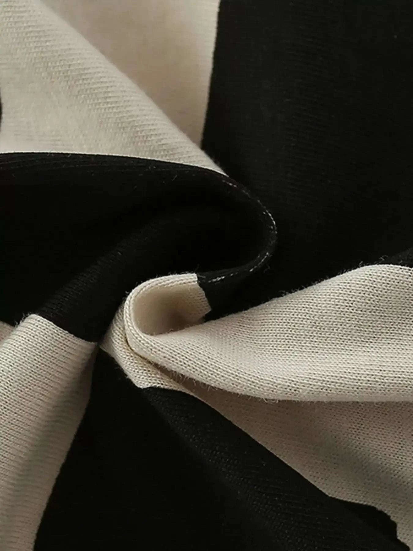 Light short-sleeve tee with dark shorts, overlapping fabric and stitched seams