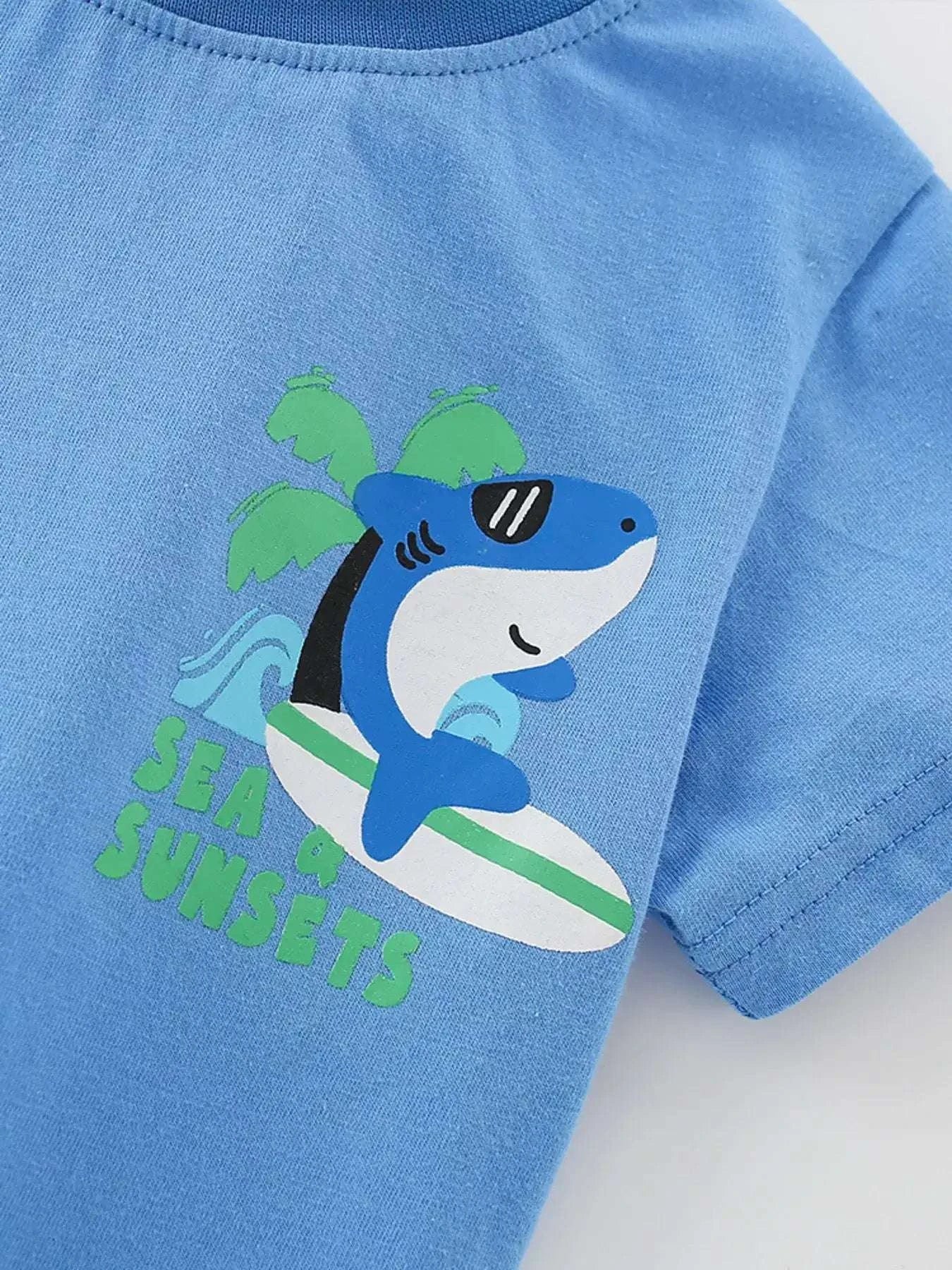 Sky blue kids tee close-up of shark graphic with green sea-sunsets text