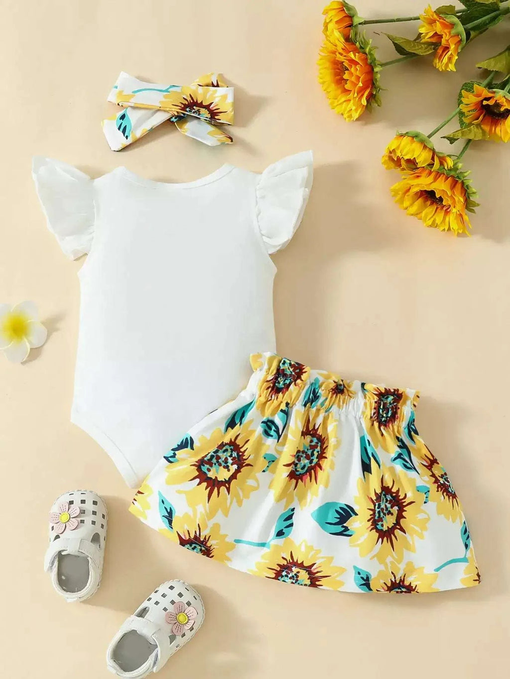 Off-white bodysuit with short sleeves and sunflower print skirt, plus bow headband