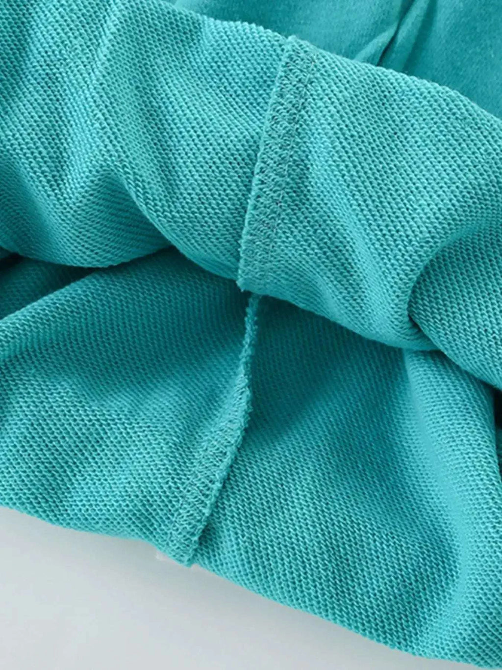 Teal kids t-shirt fabric with stitched seam and gathered fold