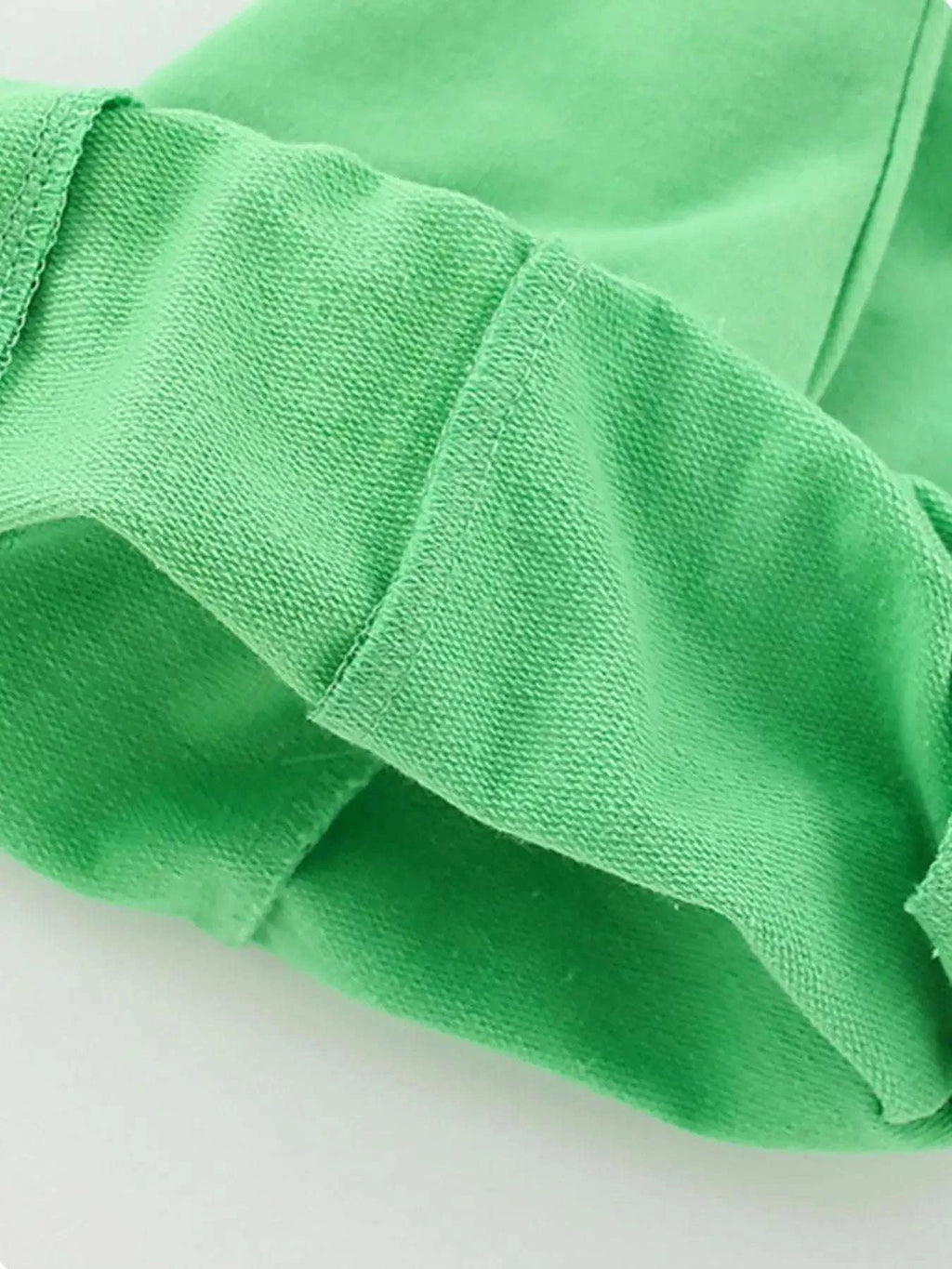 Green kids shorts fabric close-up with smooth knit texture