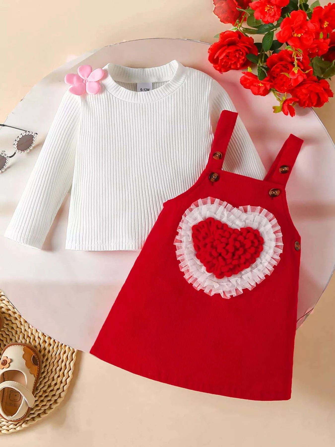Deep red corduroy overall dress with heart applique, paired with white ribbed long-sleeve top