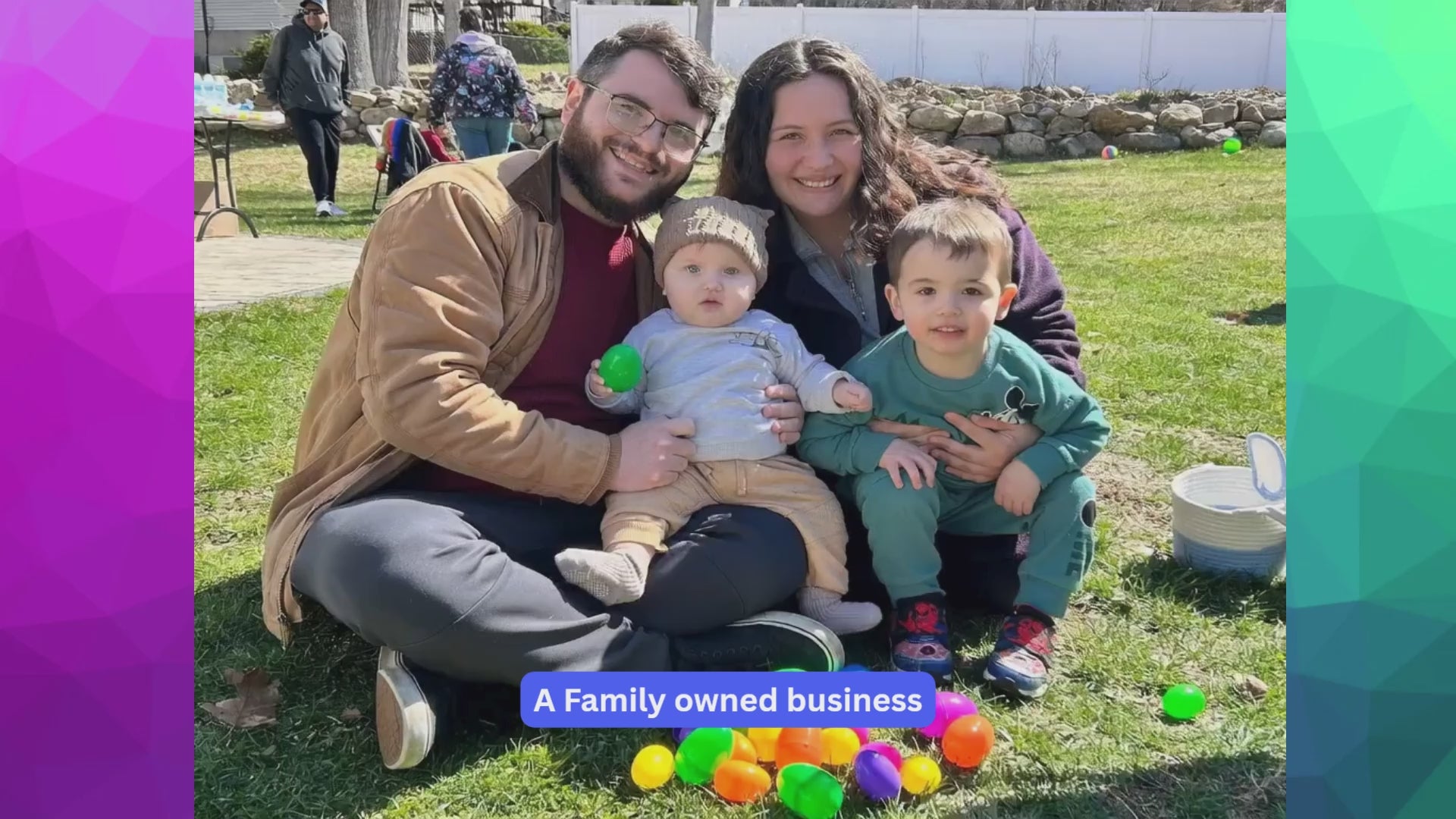 Family  of 4 grouped together sitting on grass posing for picture